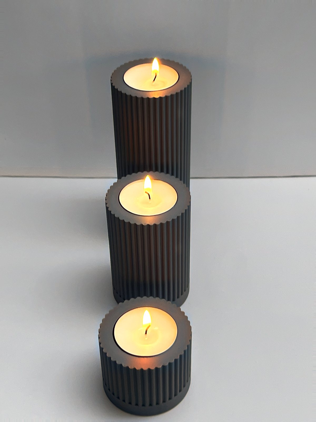 Teelichthalter gerippt, 3er-Set von Slick: Drei Teelichthalter schräg von oben (Hochformat), 3D-Druck aus mattem PLA in Grau